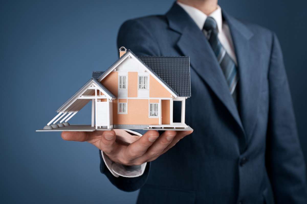 Real estate agent offer house represented by model house key